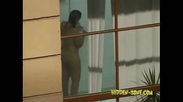 Yeni Videolar A girl washes in the shower, and we see her through the window